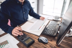 Engineer Working on Computer and Making Calculations in Office Room